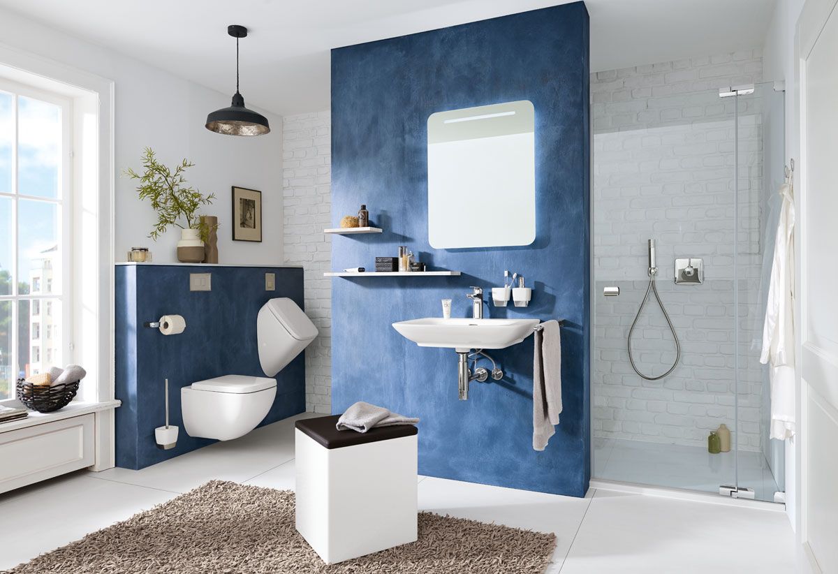 Modernes Bad mit bodengleicher Dusche, Wand-WC, Waschtisch, blauem Akzentbereich und viel Tageslicht.