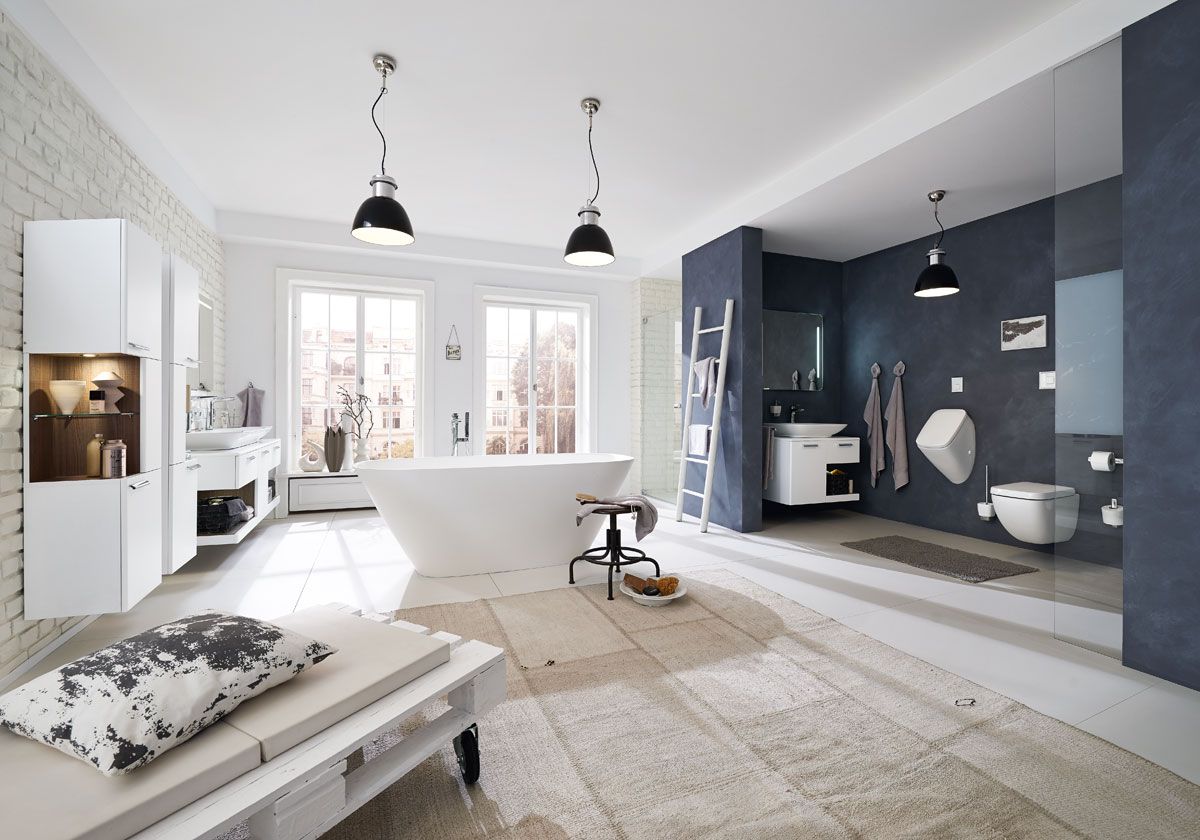 Ein modernes Bad mit Toilette, Waschbecken, Badewanne und Liegematte.